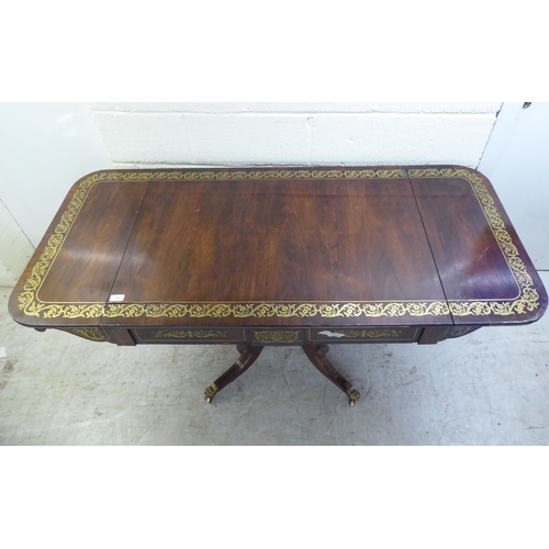 73 - A Regency brass inlaid rosewood sofa table with two frieze drawers, raised on a column and splayed q... 