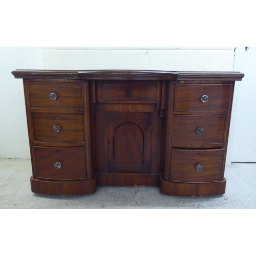 78 - A late Victorian one-piece mahogany bow breakfront, six drawer kneehole desk, on a plinth  29