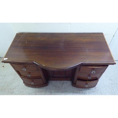 78 - A late Victorian one-piece mahogany bow breakfront, six drawer kneehole desk, on a plinth  29