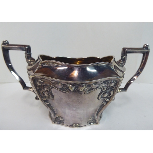 84 - An early 20thC Art Nouveau Lee & Wigfull silver plated sugar basin and milk jug, decorated with ... 