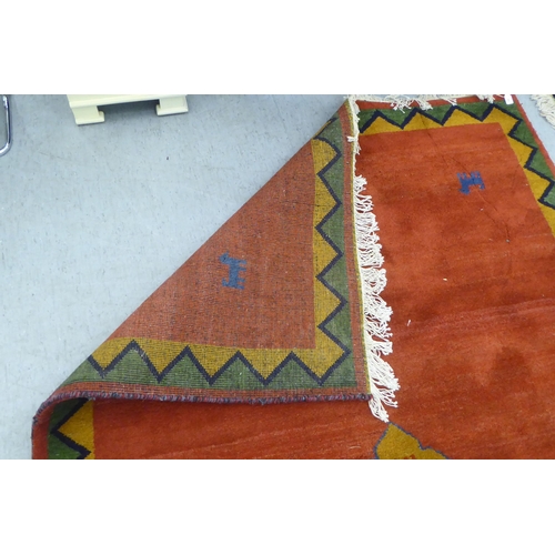 94 - A modern woollen rug, decorated with animals, on a multi-coloured ground and zig-zag border  60