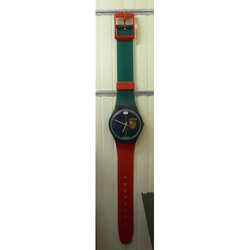 144 - A novelty battery powered wall clock, fashioned as a Swatch wristwatch  80