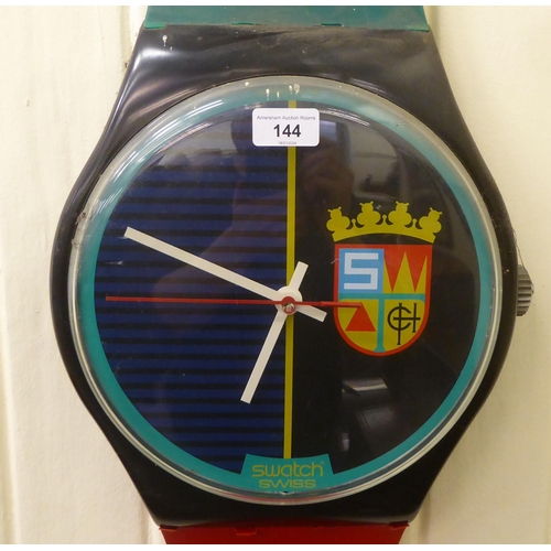 144 - A novelty battery powered wall clock, fashioned as a Swatch wristwatch  80