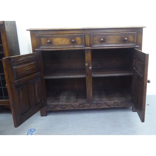 17 - A modern oak sideboard with two drawers and two panelled doors, raised on block feet  34