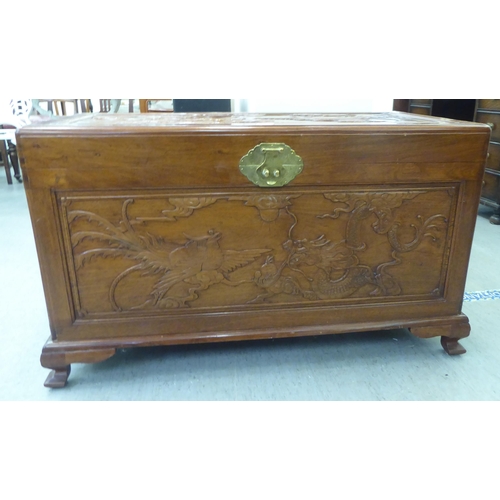 205 - A mid 20thC Chinese fruitwood chest, allover carved with dragons, raised on bracket feet  24