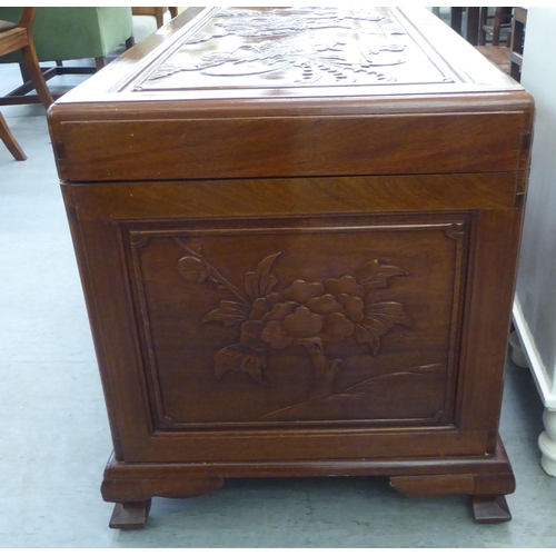 205 - A mid 20thC Chinese fruitwood chest, allover carved with dragons, raised on bracket feet  24