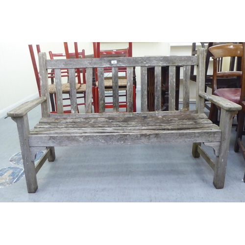 206 - A two person teak garden bench of slatted construction  48