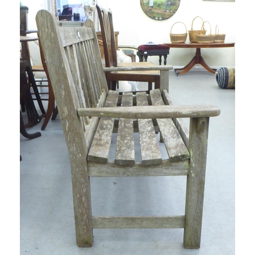 206 - A two person teak garden bench of slatted construction  48