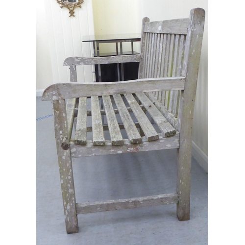 207 - A two person teak garden bench of slatted construction  48