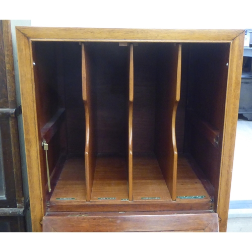 211 - A mid 20thC Chinese fruitwood music cabinet with two fall front doors, raised on bracket feet  44