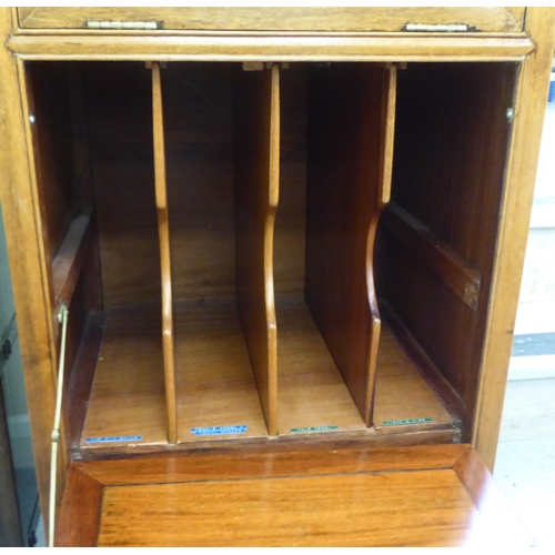 211 - A mid 20thC Chinese fruitwood music cabinet with two fall front doors, raised on bracket feet  44