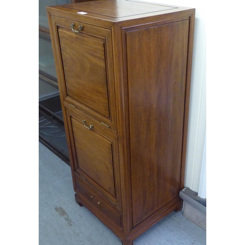 211 - A mid 20thC Chinese fruitwood music cabinet with two fall front doors, raised on bracket feet  44