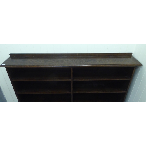 22 - A modern oak dwarf bookcase, comprising two banks of four open shelves, raised on bracket feet  44