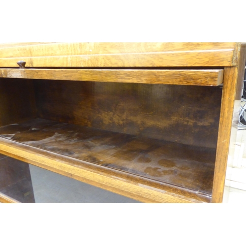 226 - A 1930s oak bookcase with three glazed lift & slide doors, raised on bracket feet  40