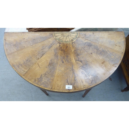 281 - A Regency satinwood demi-lune card table, the foldover sunburst veneered top enclosing a baize lined... 