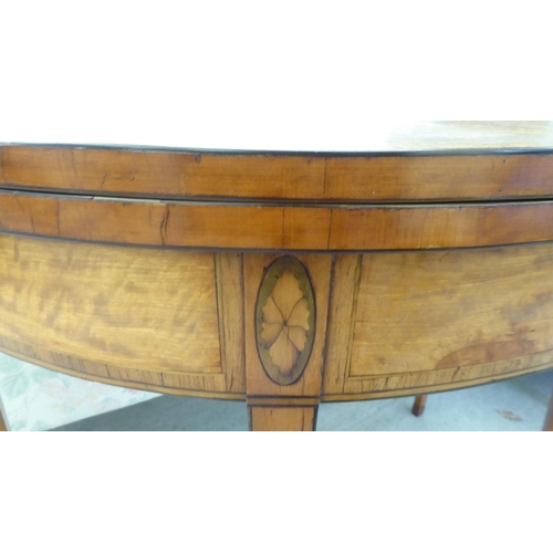 281 - A Regency satinwood demi-lune card table, the foldover sunburst veneered top enclosing a baize lined... 