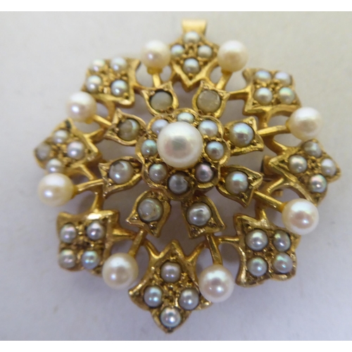 298 - A 9ct gold petal design brooch with a pendant fitting, set with blue and white tinted seed pearls