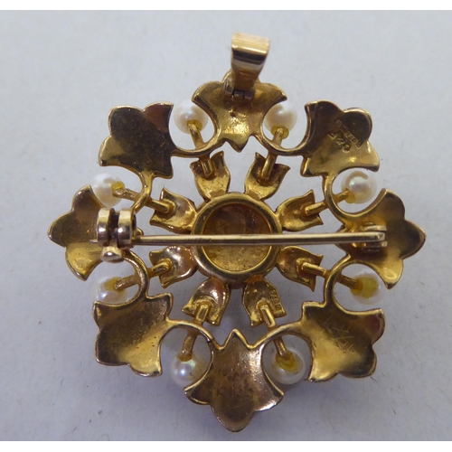 298 - A 9ct gold petal design brooch with a pendant fitting, set with blue and white tinted seed pearls