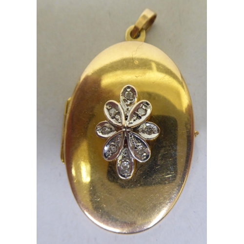 299 - A 9ct gold oval pendant locket, set with diamonds