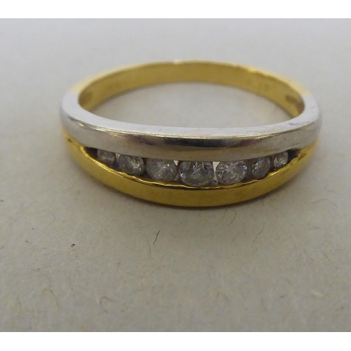 324 - An 18ct white and yellow gold ring, set with a band of diamonds