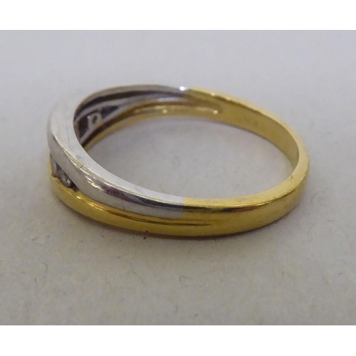 324 - An 18ct white and yellow gold ring, set with a band of diamonds