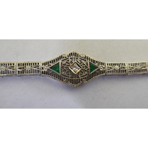 336 - A 14ct white gold filigree bracelet, set with green and white stones