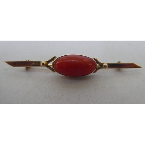 340 - A 9ct gold bar brooch, set with a coral cabochon 