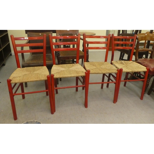 349 - A set of four red stained beech framed kitchen chairs, each with a rush seat, raised on turned legs