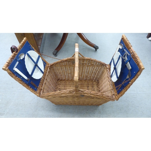 352 - A modern wicker picnic basket, containing two place settings of cutlery and flatware