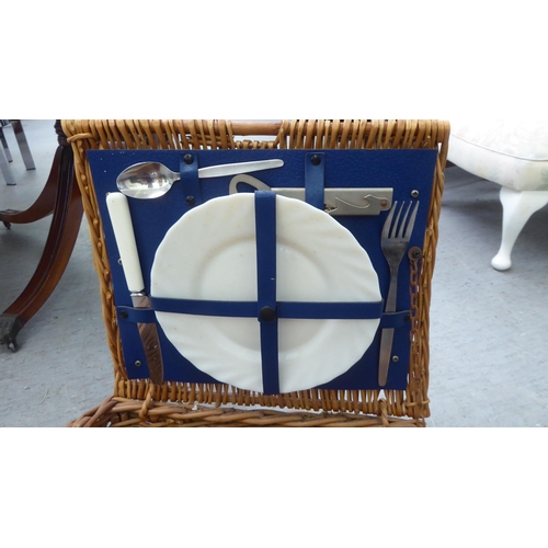 352 - A modern wicker picnic basket, containing two place settings of cutlery and flatware