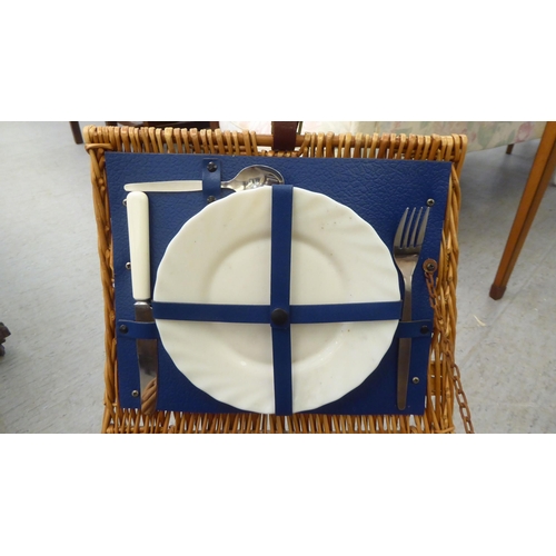 352 - A modern wicker picnic basket, containing two place settings of cutlery and flatware