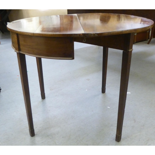 377 - A Regency mahogany demi-lune card table with a foldover top, raised on square, tapered legs  28... 