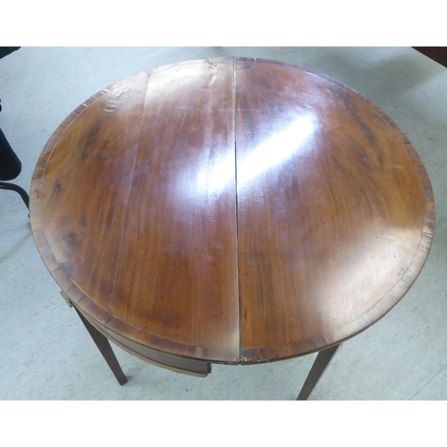 377 - A Regency mahogany demi-lune card table with a foldover top, raised on square, tapered legs  28... 