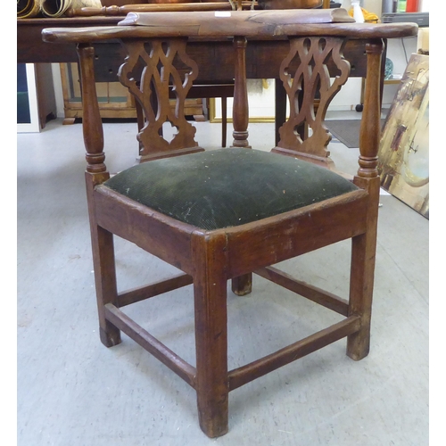 382 - A George III oak corner chair with a double splat back and drop-in seat, raised on square legs