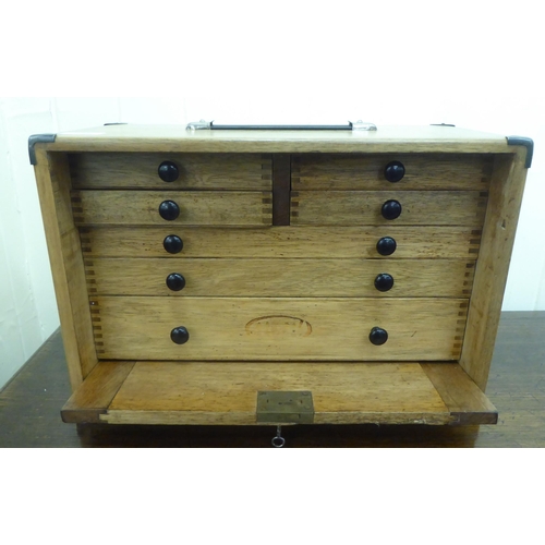 389 - A mid 20thC oak engineer's tool chest, the removeable front panel enclosing seven drawers  11