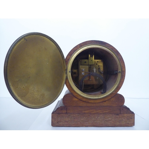 4 - An early 20thC oak mantel clock, faced by a Roman dial, on a plinth  11