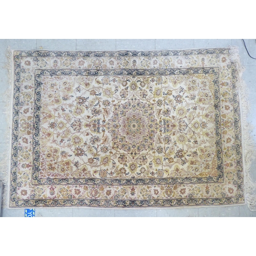 99 - A Persian rug with floral motifs, on a beige ground  70