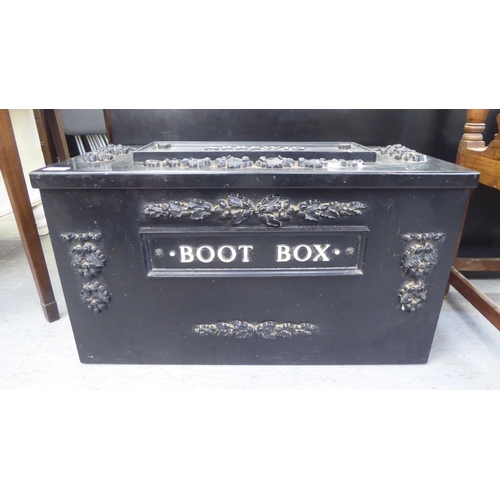 153 - A modern cast metal, black painted boot box, decorated with floral motifs, having an address plate f... 