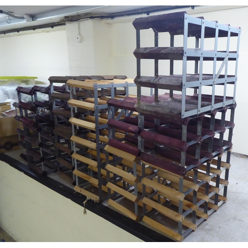 27 - Seven wooden and metal wine racks  largest with provision for 24 bottles  25