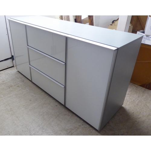 275 - A modern white and grey laminate and satin silver coloured metal mounted sideboard, comprising a ban... 