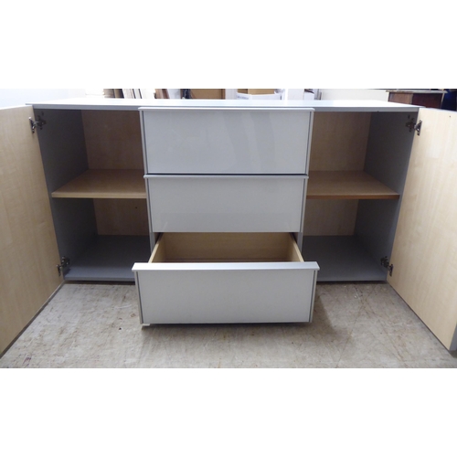 275 - A modern white and grey laminate and satin silver coloured metal mounted sideboard, comprising a ban... 