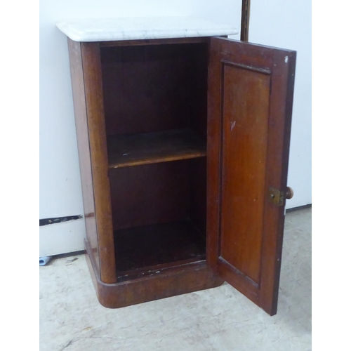 145 - A late Victorian mahogany pot cupboard with a mottled grey marble top, over a full height door, on a... 