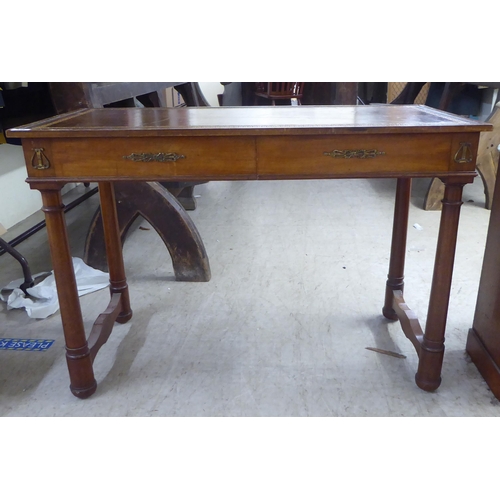 148 - A mid 20thC Continental style mahogany writing table with a tooled and gilded old gold coloured hide... 