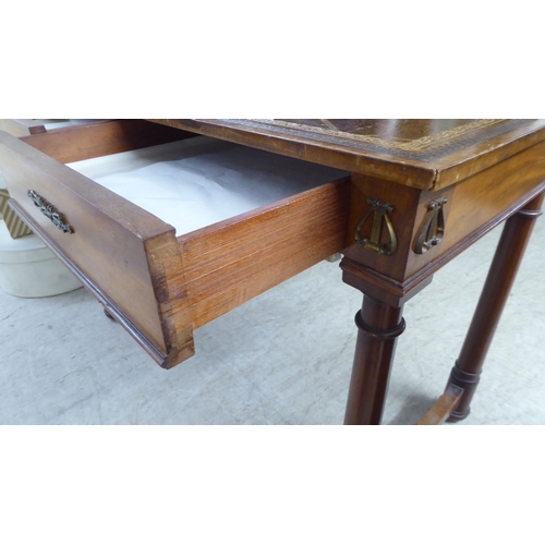 148 - A mid 20thC Continental style mahogany writing table with a tooled and gilded old gold coloured hide... 