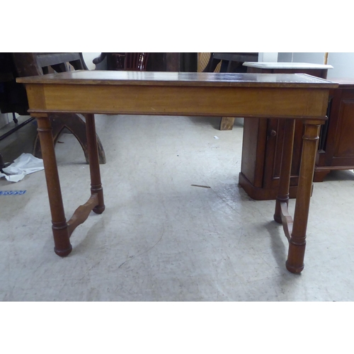 148 - A mid 20thC Continental style mahogany writing table with a tooled and gilded old gold coloured hide... 