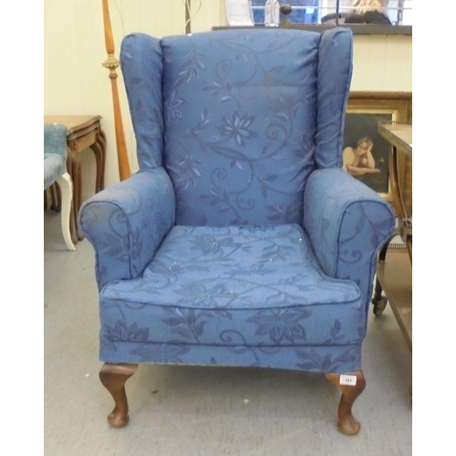 191 - A modern blue fabric upholstered wingback armchair, raised on cabriole legs