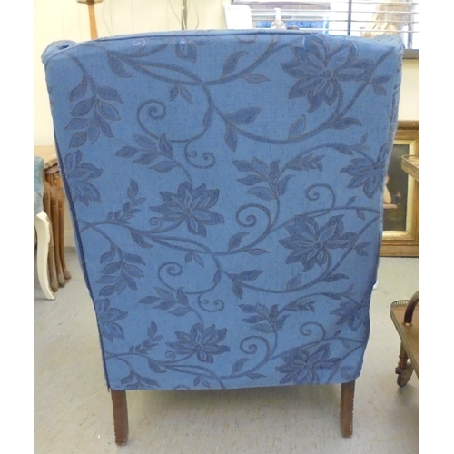 191 - A modern blue fabric upholstered wingback armchair, raised on cabriole legs