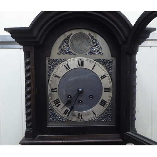 194 - An early 20thC oak cased granddaughter clock, the arched hood decorated with barleytwist columns, co... 