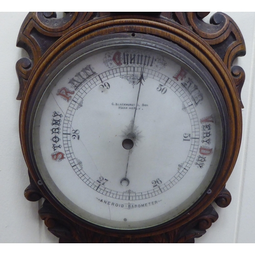 195 - An early 20thC oak cased aneroid barometer by G.Blackhurst & Son with a painted enamel dial ... 