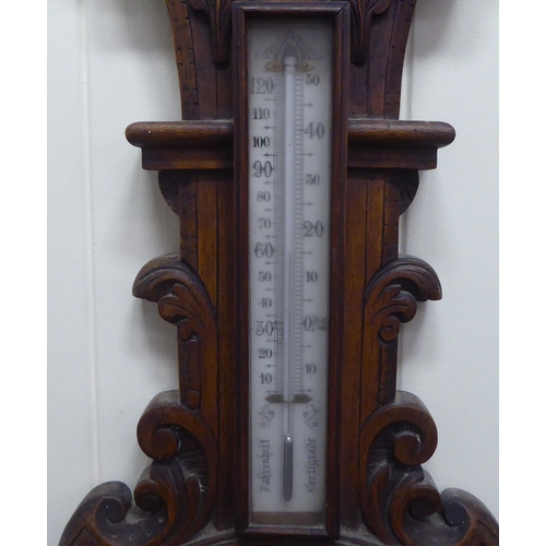 195 - An early 20thC oak cased aneroid barometer by G.Blackhurst & Son with a painted enamel dial ... 